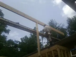 Carpenter setting a ridge beam over a new addition frame — Ice Dam Removal by Roofing Brothers in Freeman